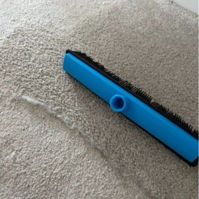 balai coiffeur bleu posé sur tapis