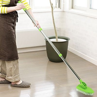 femme nettoie sol avec brosse télescopique vert