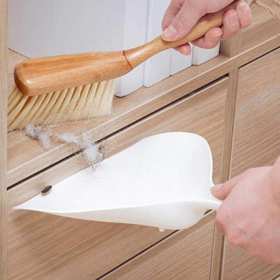 elle nettoie poussière meuble pelle et balayette