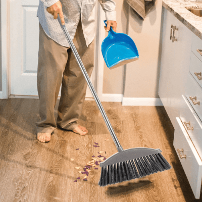 femme balaye cuisine avec balai gris