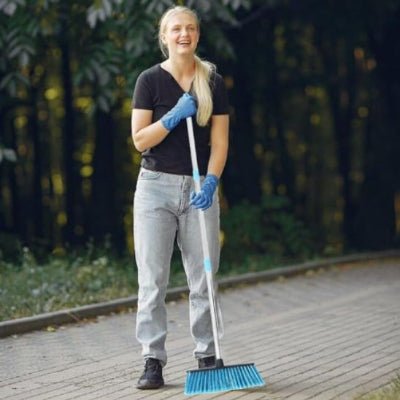 femme balaye extérieure avec balai bleu
