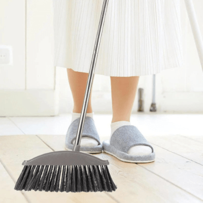 femme balaye salon avec balai gris