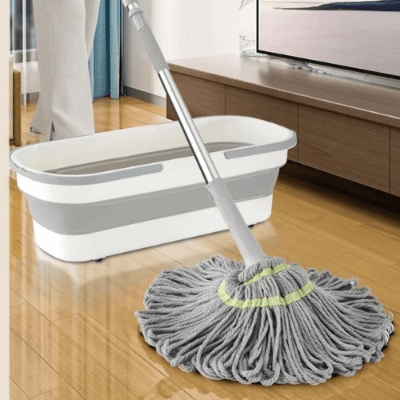 femme nettoie salon avec balai frange