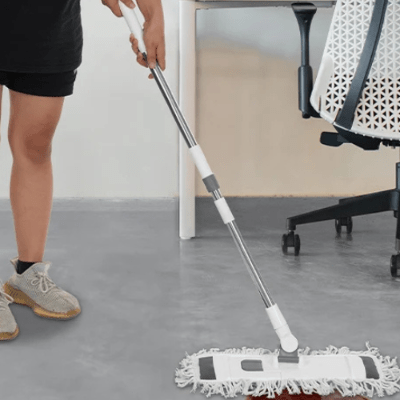 femme nettoie sous bureau avec serpillere blanc