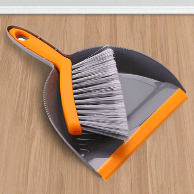 pelle balayette gris orange sur sol salon